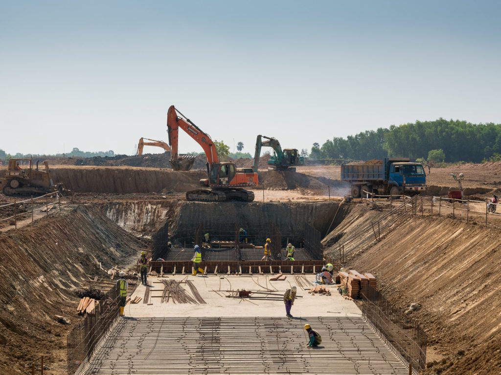 Zware machines en bouwvakkers werken aan een gebouw.